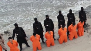 Still image from video shows men purported to be Egyptian Christians kneeling in front of armed men along beach said to be near Tripoli
