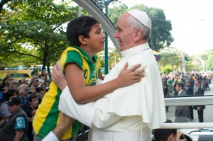 Pope Francis embraces boy as he arrives to hear confessions during World Youth Day in Rio de Janeiro