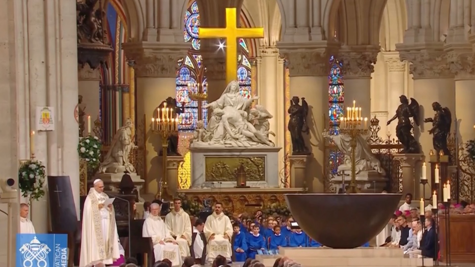 Le pape Léon XIV préside les vêpres à l’intérieur de la cathédrale Notre-Dame de Paris, debout devant l’autel sous une grande croix illuminée, entouré de membres du clergé, de séminaristes et de jeunes.