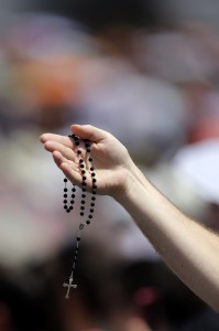 Man holds rosary as Pope Francis delivers Angelus address in St. Peter's Square at Vatican